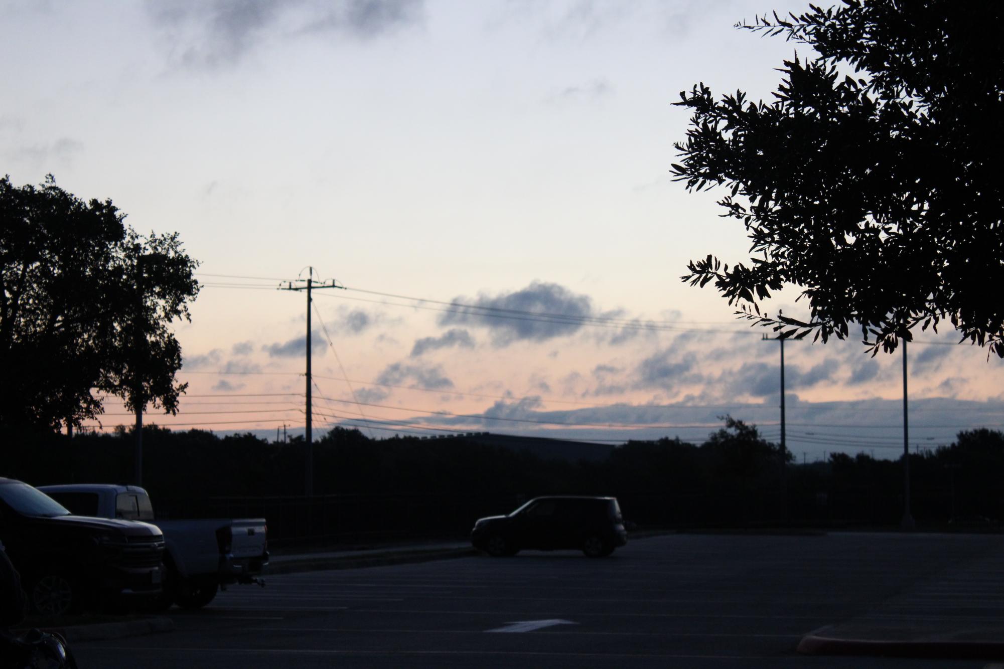 On the warm morning of Sep 6, 2024, a colorful pink and blue sunrise paints the sky as seniors gather. 