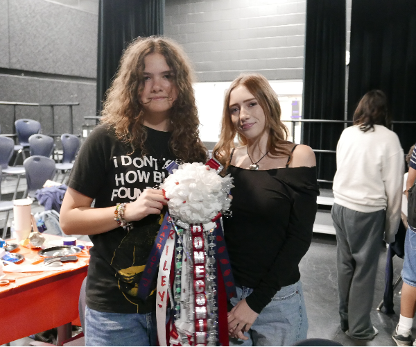 Junior Addison Goolsby (Left) and Sophomore Olivia Memelo (Right) present freshly assembled mum.